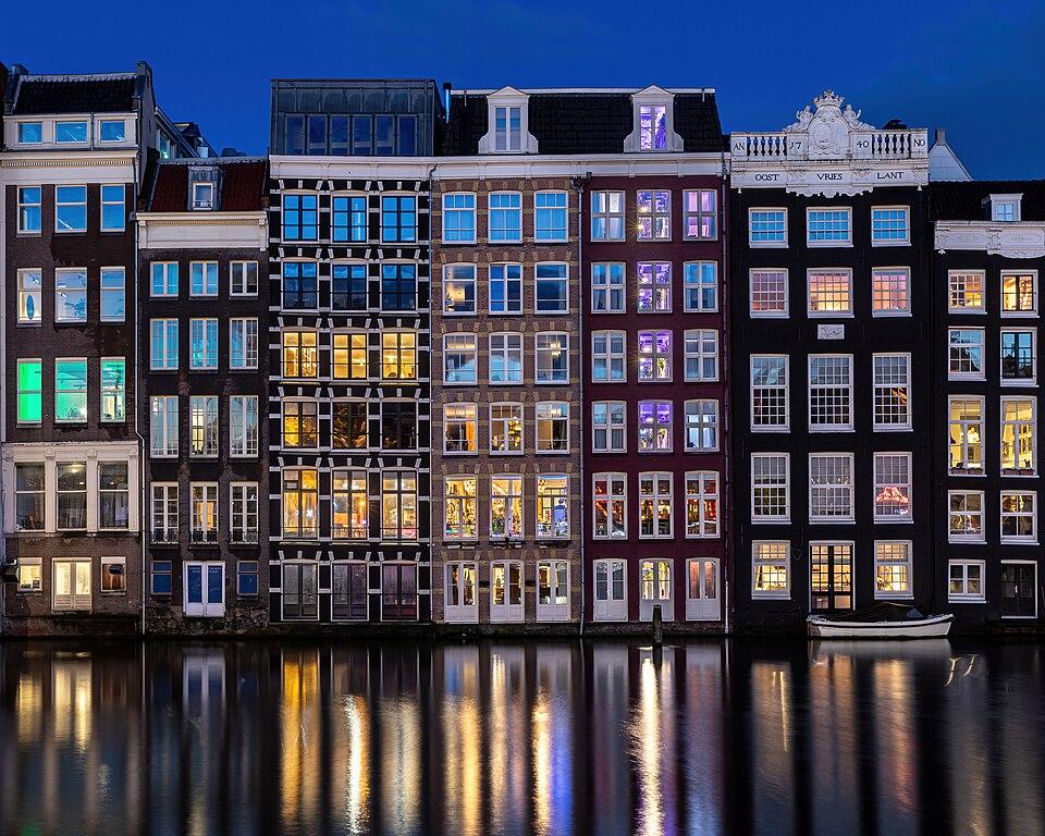 Olanda — imagine ilustrativă: Water reflection of canal houses at blue hour in Damrak Amsterdam the Netherlands.jpg