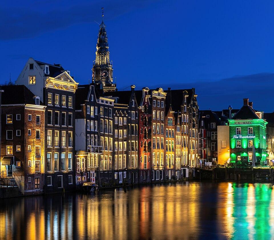 Olanda — imagine ilustrativă: Canal houses and Oude Kerk at blue hour with water reflection in Damrak Amsterdam Netherlands.jpg
