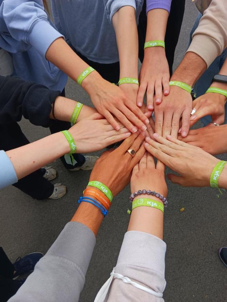 voluntariat — imagine ilustrativă: Hands of German volunteers cheering.jpg