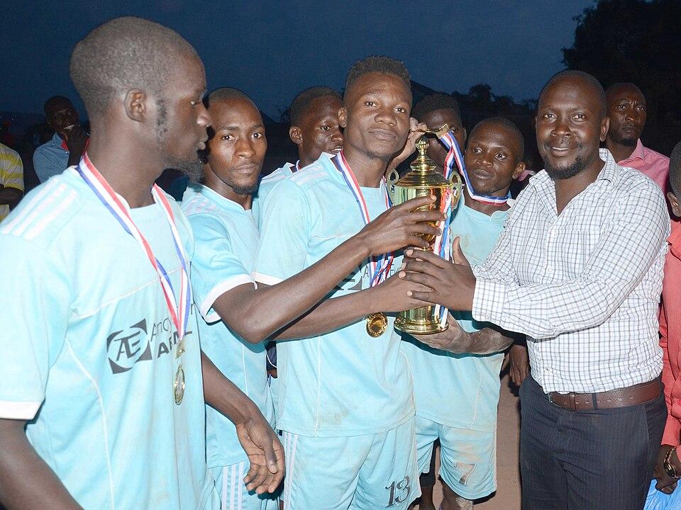 premieri — imagine ilustrativă: Muhsin Kyambadde awarding Harunah Kasujja kapiteeni of Patu Select the trophy of kalatiini Cup.jpg